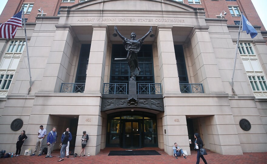 People wait in line Tuesday to enter the Albert V. Bryan United States Courthouse in Alexandria, Va., to attend the trial of former Trump campaign chairman Paul Manafort.