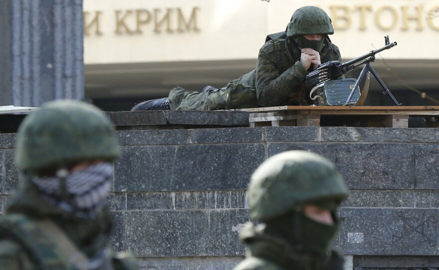 Armed men take up positions around the regional parliament building in the Crimean city of Simferopol on Saturday. Ukraine's defense minister said on Saturday Russia had "recently" brought 6,000 additional personnel into Ukraine.