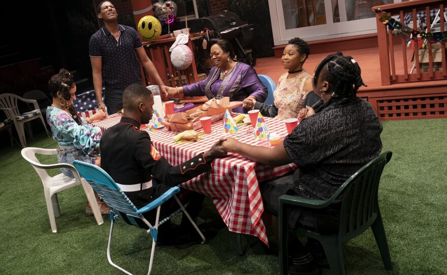 The cast of Fat Ham gathered around the dinner table.