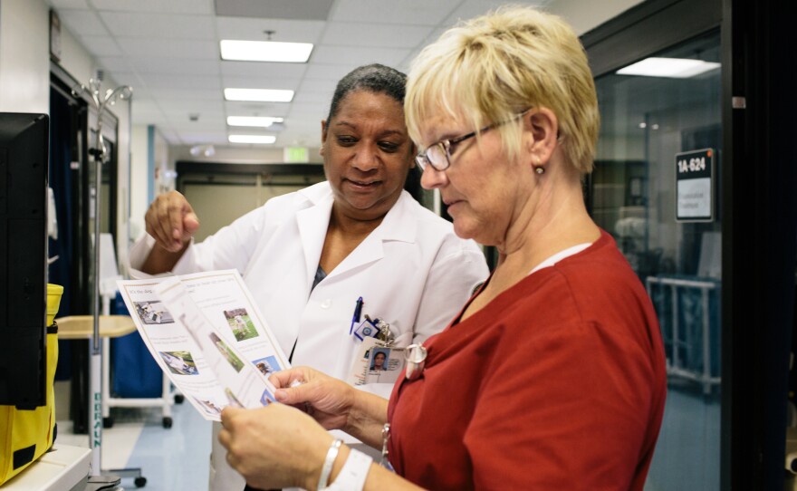 Tony Hilton (left), the safe patient handling and mobility coordinator at the VA hospital in Loma Linda, gives Ruby Baker a safety tip sheet.