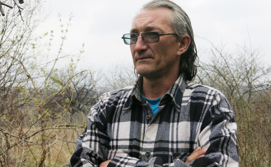 Oleg Kovalenko, 44, was injured on his left shoulder when a shell exploded overhead on the evening of April 5 while he and a neighbor were smoking cigarettes and drinking beers outside his fence. He says he can't afford to leave or repair his property, which is pockmarked from three years of shrapnel and bullets.