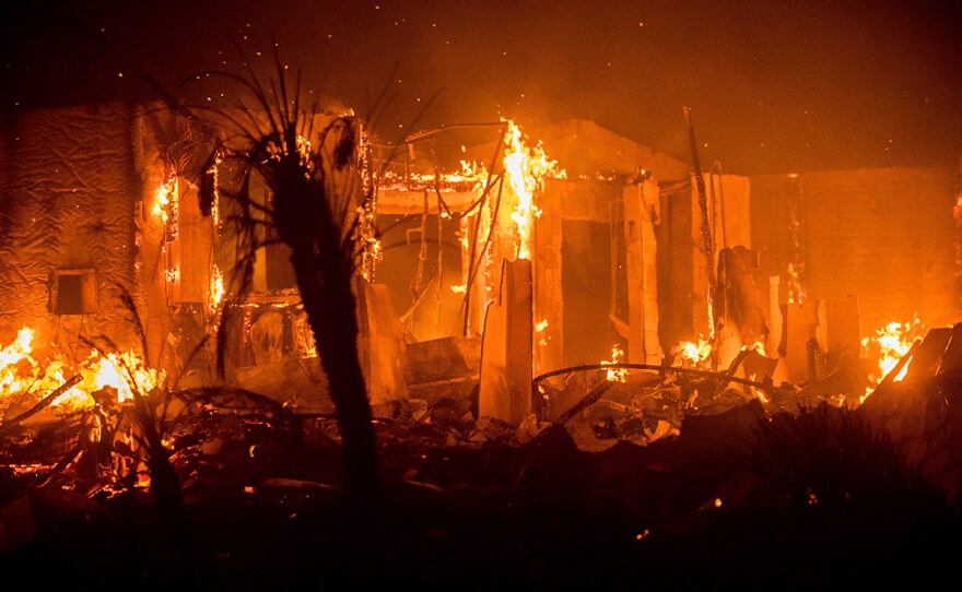 Flames consume a structure as the Lilac fire burns in Bonsall, Calif., on Friday, Dec. 8, 2017.