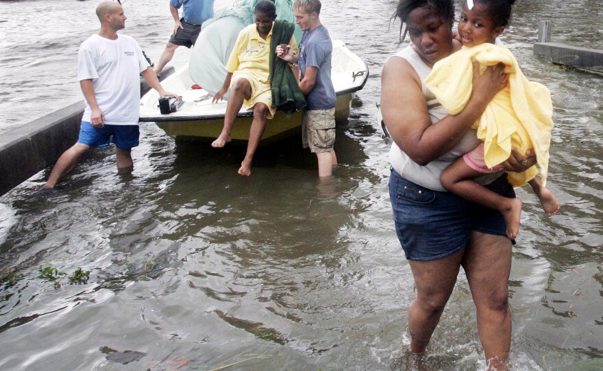 Shante Gruld carries Janeka Garner, 5, to safety after they were rescued from their flooded home by boat in New Orleans on Aug. 29, 2005. The area was flooded after Hurricane Katrina hit the area.