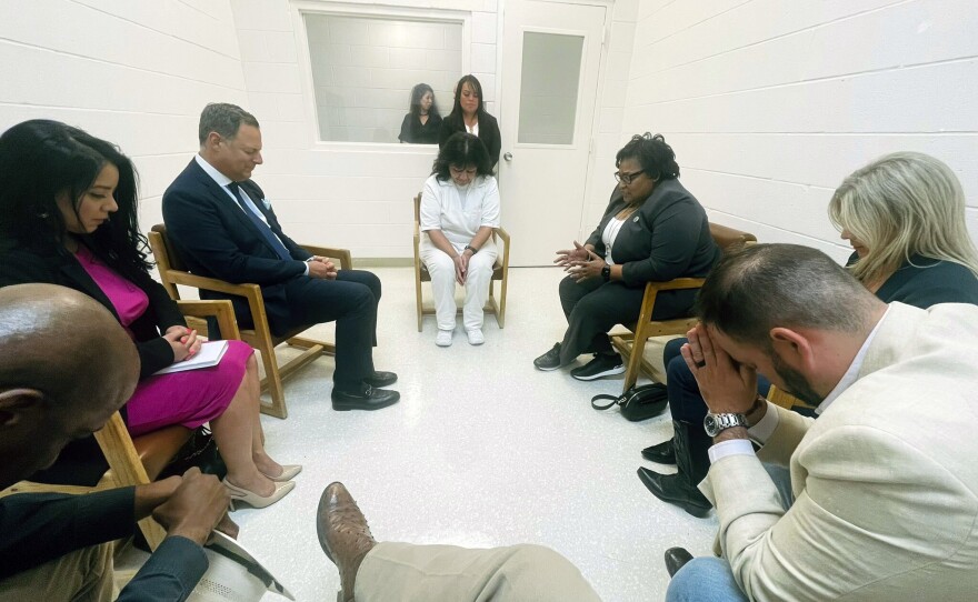In this April 6, 2022 photo provided by Texas state Rep. Jeff Leach, Texas death row inmate Melissa Lucio, dressed in white, leads a group of seven Texas lawmakers in prayer in a room at the Mountain View Unit in Gatesville, Texas.