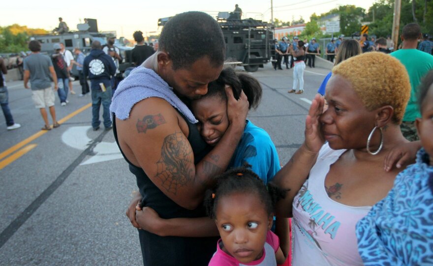 "I'm out here to stand for my children and their future," said Terrell Williams El, who hugged his daughter while standing with his wife and two daughters near the QuickTrip in Ferguson, Mo., Wednesday. Several other residents say they've often felt harassed by police.