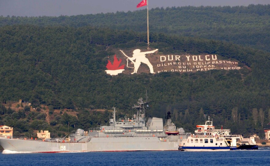 The Russian naval ship Caesar Kunikov passes through the Dardanelles strait in Turkey to the Mediterranean Sea Sunday. The memorial on the mountain commemorates the World War I Gallipoli campaign, with a sign citing a Turkish poem: "Stop passenger. The land you come upon without knowing is the place an era had ceased." Russia began launching military operations in Syria last Wednesday.