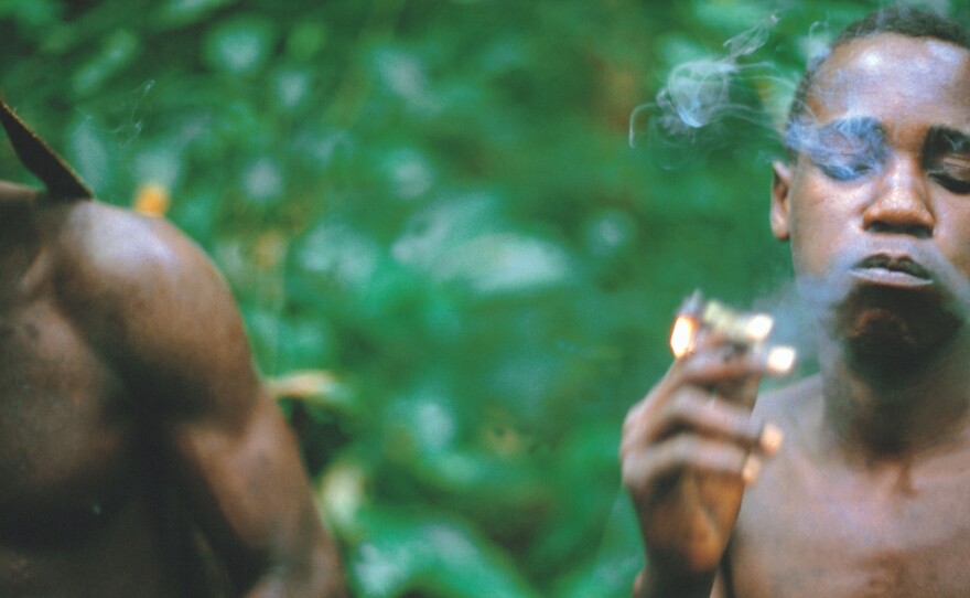 An Aka man smokes hemp while hunting in the Central African Republic.
