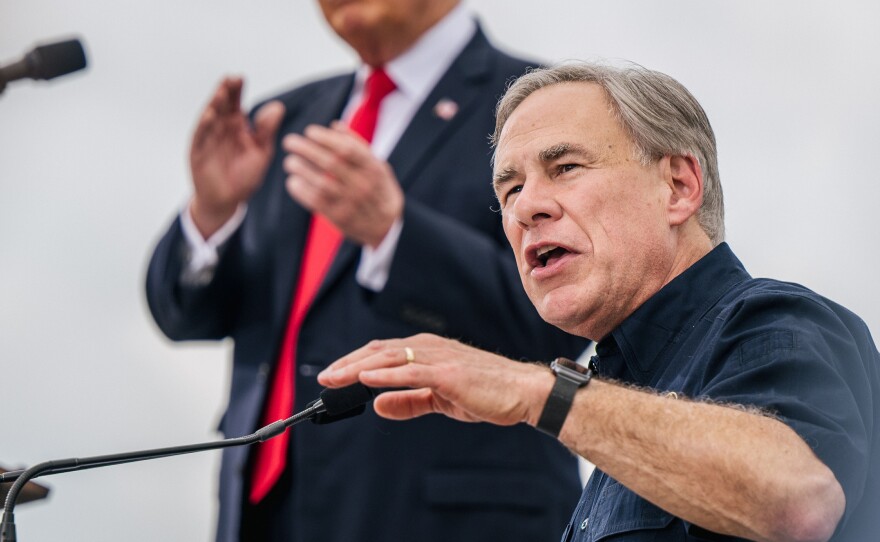 Texas Gov. Greg Abbott speaks alongside former President Donald Trump during a tour of an unfinished section of the border wall on June 30 in Pharr, Texas. Abbott says he'll continue Trump's border barrier, a pledge that is expected to help the governor in his reelection campaign.