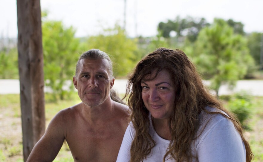 Erik Ryan and Mia Reynolds from San Leon, Texas, wait on hold with FEMA at their campsite at Bastrop State Park in Texas on Sunday. Running out of money and resources, they were relieved to hear Texas Gov. Greg Abbott's announcement that Texas State Parks were open for the month of September for evacuees, free of charge.