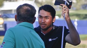 Jason Day, right, shakes hands with J.B. Holmes after winning a playoff against Holmes at the Farmers Insurance Open at the Torrey Pines Golf Course on the second extra hole with a par, Feb. 8, 2015.
