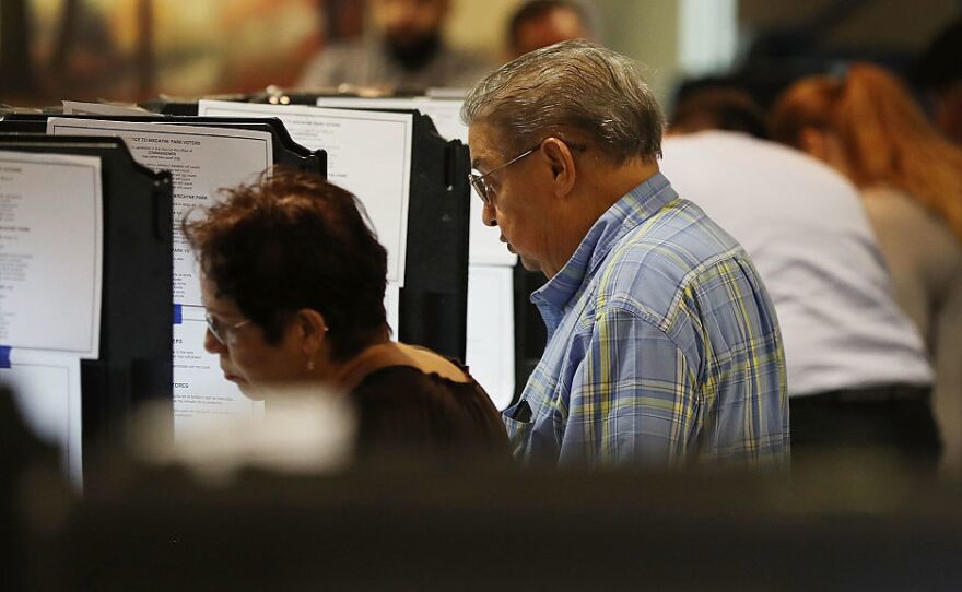 Voters cast their votes at an early voting center in Miami, Fla.