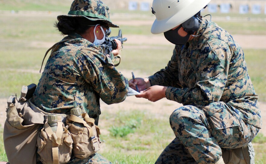 A combat marksmanship coach is evaluating a Marine recruit's shots on the Bravo shooting range on Camp Pendleton, April 7, 2021.