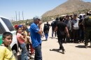 Migrants gather to recieve donated food and water in the Jacumba Wilderness, May 12, 2023. Hundreds have been in the area for days with little food and water and no shelter while waiting to be processed by Customs and Border Patrol.