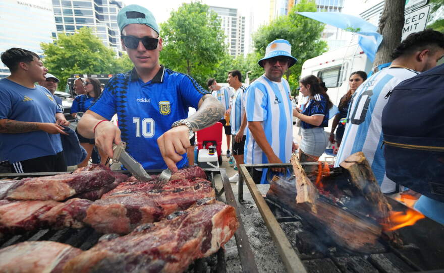 Matias Videla, of Dallas, a supporter of Argentina, checks meat on his grill during a rally ahead of his team's World Cup Group J soccer match against Austria, Sunday, June 21, 2026, in Dallas.