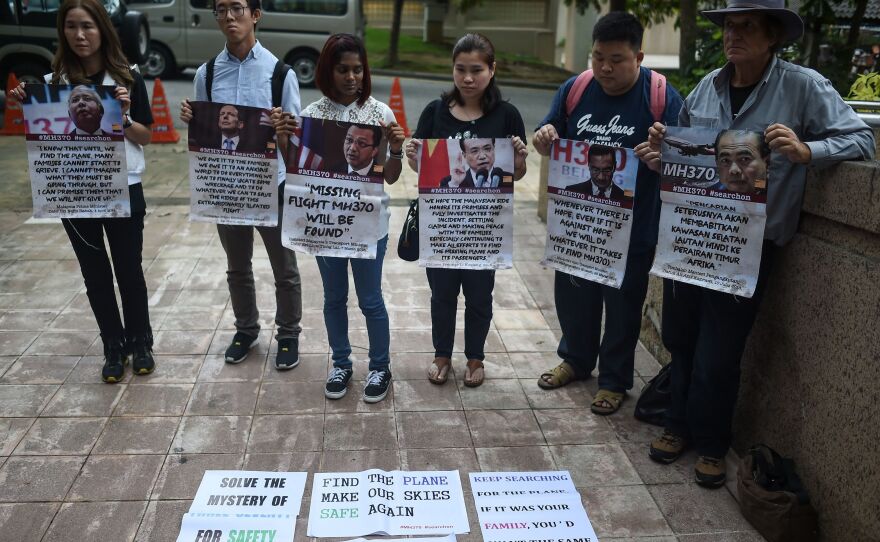 Relatives of passengers on Malaysia Airlines Flight 370 hold placards following a joint press conference on the search for the missing airliner Friday. The search will be suspended if nothing turns up in the current area, officials say.