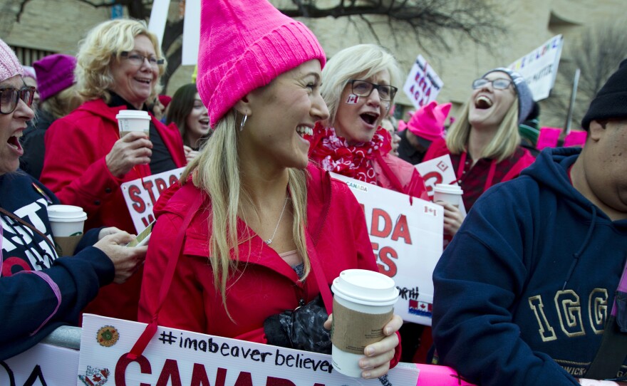 Women with bright pink hats and signs gather early on Saturday in Washington, D.C. for the Women's March on Washington.