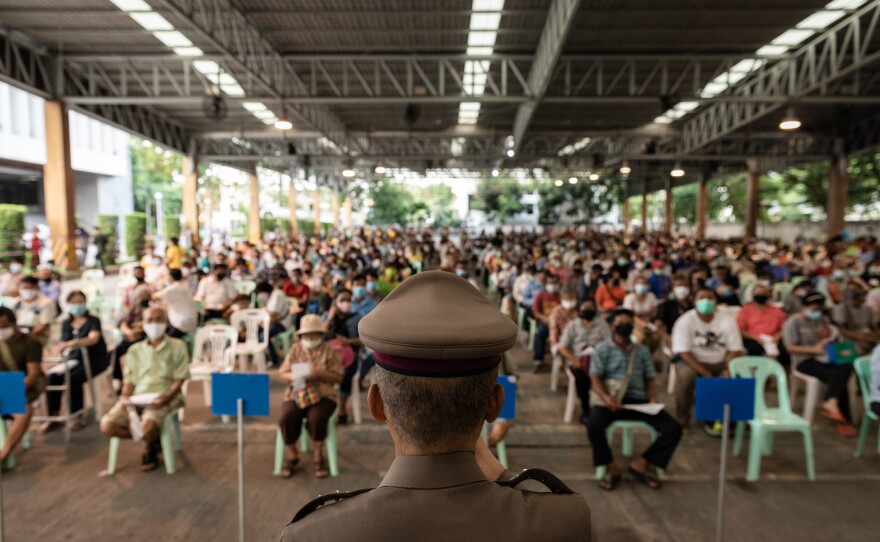 People in Bangkok work on their application forms to receive 5,000 Thai baht — about $150 U.S. The financial assistance is available for those whose income has dropped because of COVID-19 preventive measures.