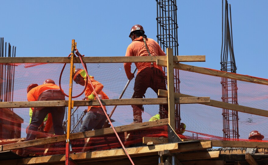 Construction workers work on a construction site in Brooklyn, N.Y., on July 22.