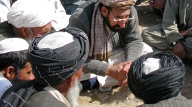 Haji Zahir, the new governor of Marjah in Helmand province, listens to residents' grievances Monday. It was the first time an Afghan government official visited the former Taliban stronghold in two years.