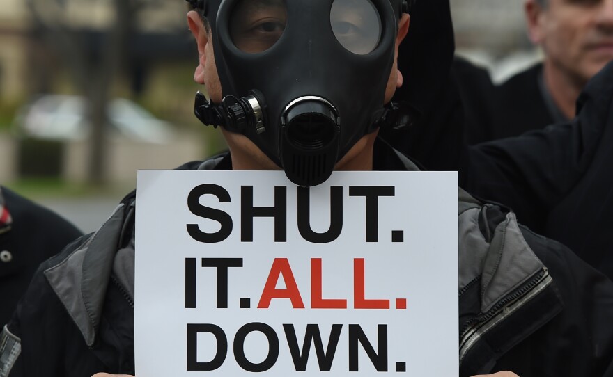 A Porter Ranch resident wears a gas mask during a protest Saturday outside a meeting of the Air Quality Management Board over the Aliso Canyon gas leak. The leak started in October and has forced thousands of residents to flee from the Los Angeles suburb of Porter Ranch. Regulators have ordered the gas company to shut down the leaking well; some residents want the entire facility shuttered.