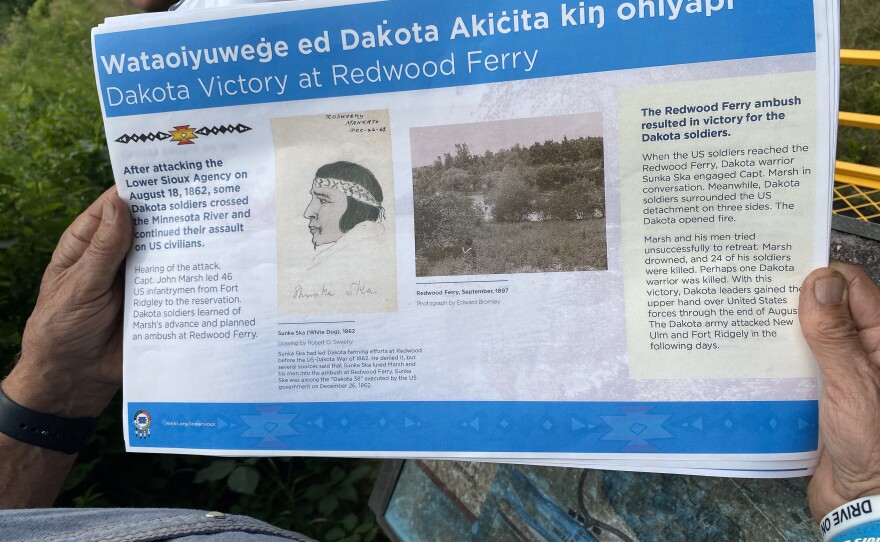 John Robertson holds a version of the new signs, which are written in both Dakota and English.