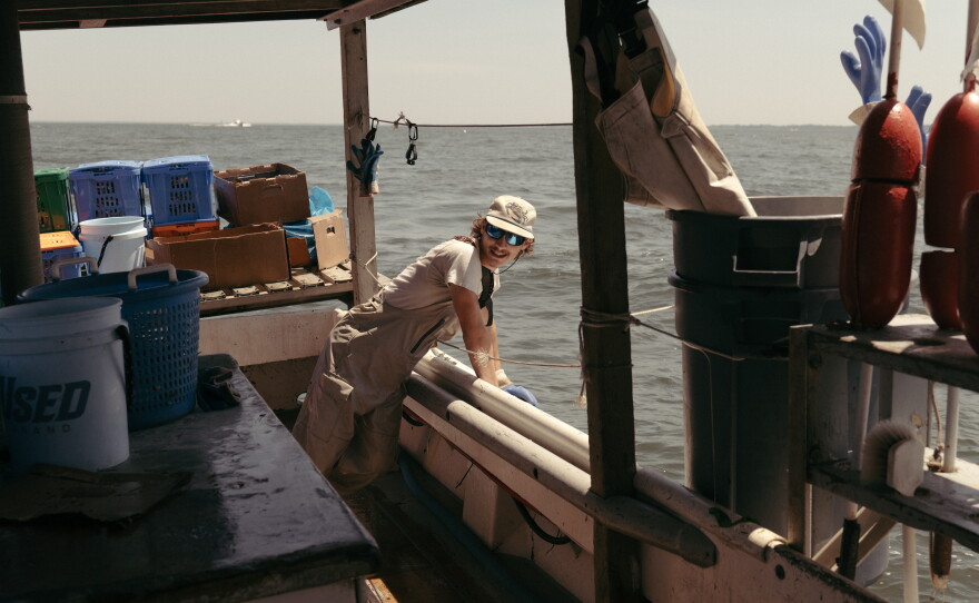 Jordan Lynn leans off the side of Luke McFadden's crab boat near Sandy Point State Park, in Annapolis, Maryland.