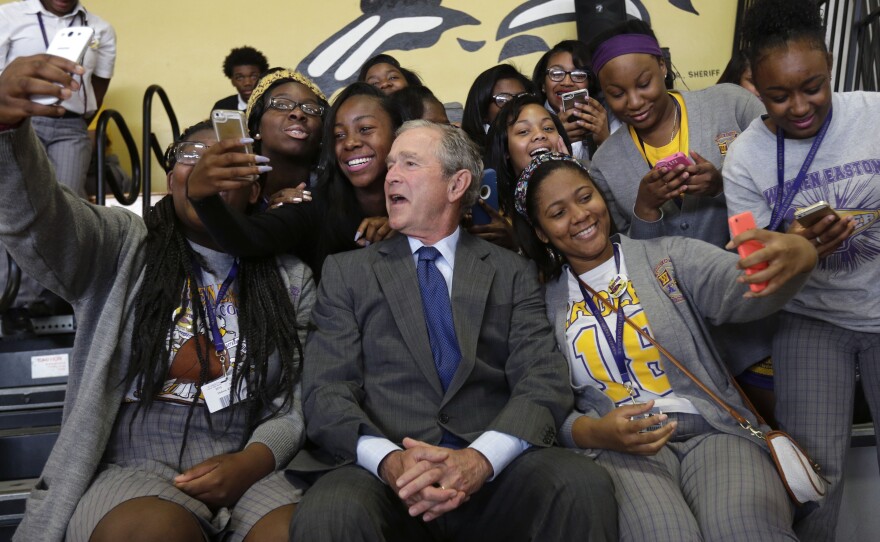 Former President George W. Bush poses for photos with students at Warren Easton Charter High School in New Orleans, on Friday. He was visiting the city on the 10th anniversary of Hurricane Katrina.