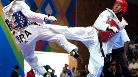 Terrence Jennings (right) lands a kick during a taekwondo match last fall. Jennings, who says his love of the <em>Teenage Mutant Ninja Turtles</em> drew him to the sport, will compete in his first Olympics this summer.