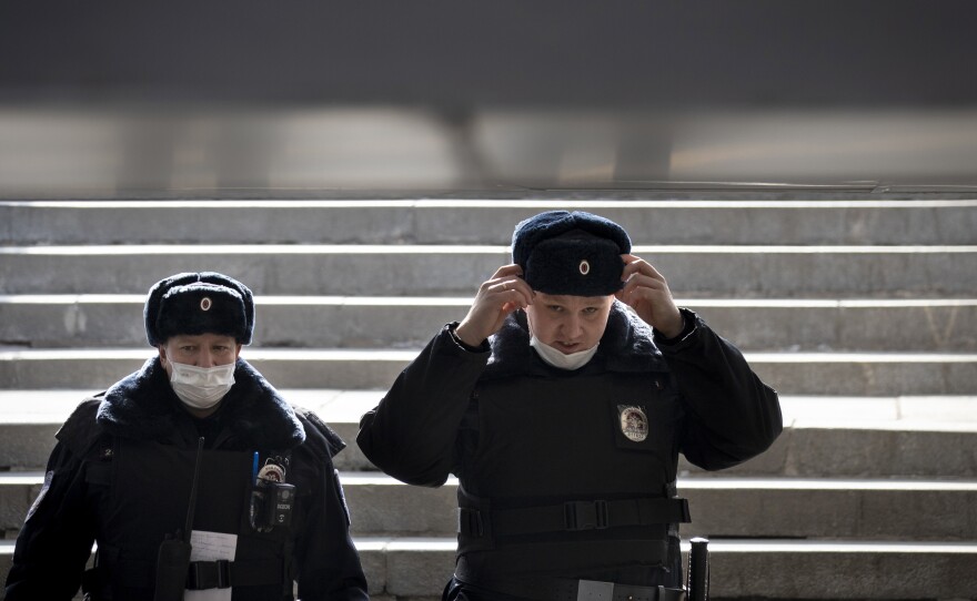 Russian police officers, wearing face masks to guard against the coronavirus, descend into a pedestrian underpass as they patrol to enforce a self-isolation regime in Moscow.
