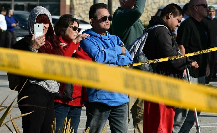 Bystanders watch law enforcement agents breaking into a van containing the suspect's body in Torrance, California, on Sunday.