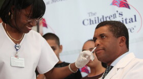 Nurse Melody McKever (L) administers a nasal spray dose of the H1N1/swine flu vaccine to Pediatrics Chairman Dr. Philip Ozuah at Montefiore Medical Center October 6, 2009 in the Bronx borough of New York City. 