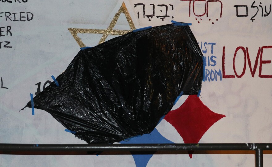 A black trash bag covers a red swastika painted over a mural at Duke University. Dedicated to the victims of the Pittsburgh synagogue shooting, the original mural replaced the yellow star in the Pittsburgh Steelers' emblem with the Star of David and read, "We must build this world from love."