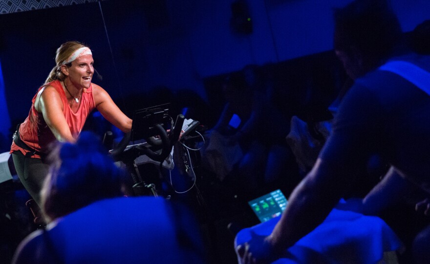Peloton indoor cycling instructor Jen Sherman leads classes and also monitors metrics for riders taking classes outside the studio.