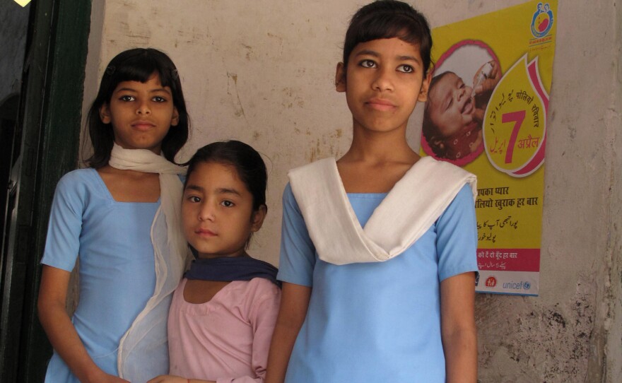 The whole community comes out during the polio vaccination campaigns. These school girls stopped by an immunization booth just to watch the action.