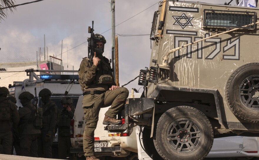 A member of the Israeli security forces stands guard. An attack against troops was reported near the West Bank city of Hebron on Feb. 1. Many settlers have joined the military's regional defense units since the Oct. 7 attack on Israel by Hamas-backed militants.