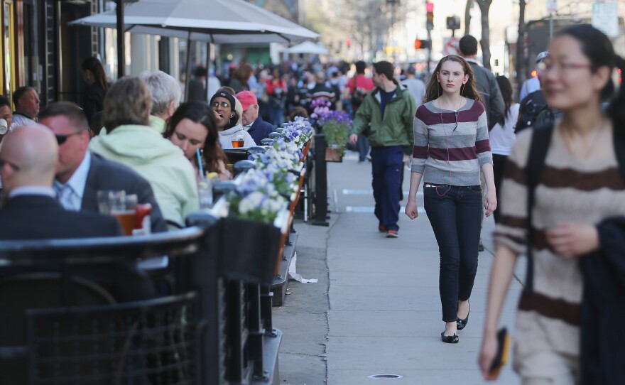 People walk and eat along Boylston Street, near the site of the Boston Marathon bombings, on Wednesday. Businesses in the area have reported strong customer support; they also have an option for federal loans to help them cope with losses.