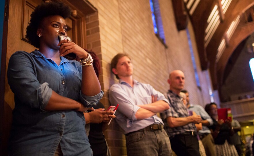 Ashley Yates (left) listens to the panel discussion. Members of the audience packed the Wellspring Church and shared similarly emotional reactions to recent events.