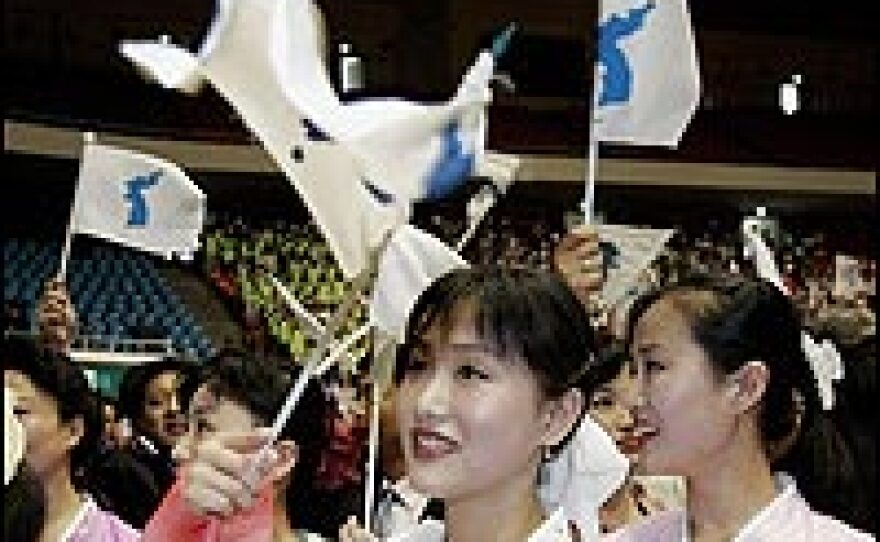 On Friday, North Korean women waved unification flags at the closing ceremony of the sixth anniversary of a June 2000 summit in Gwangju. But relations between their nation and the U.S. and Japan got more tense Saturday.