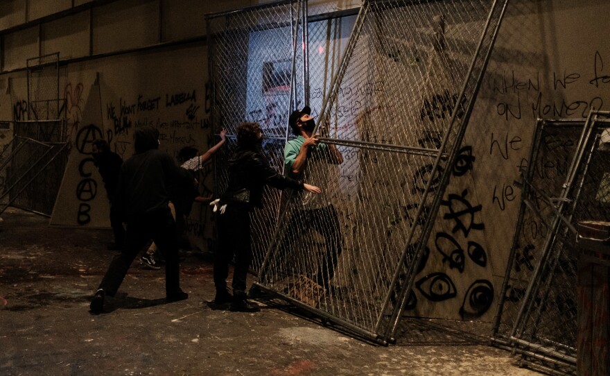 Protesters attempt to barricade the entrance to the U.S. District Court building on July 17 in Portland, Oregon.