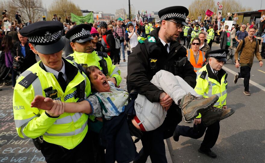 Police arrest a climate change activist near Waterloo Bridge in London on Wednesday. Authorities have made about 300 arrests since protests began Monday.