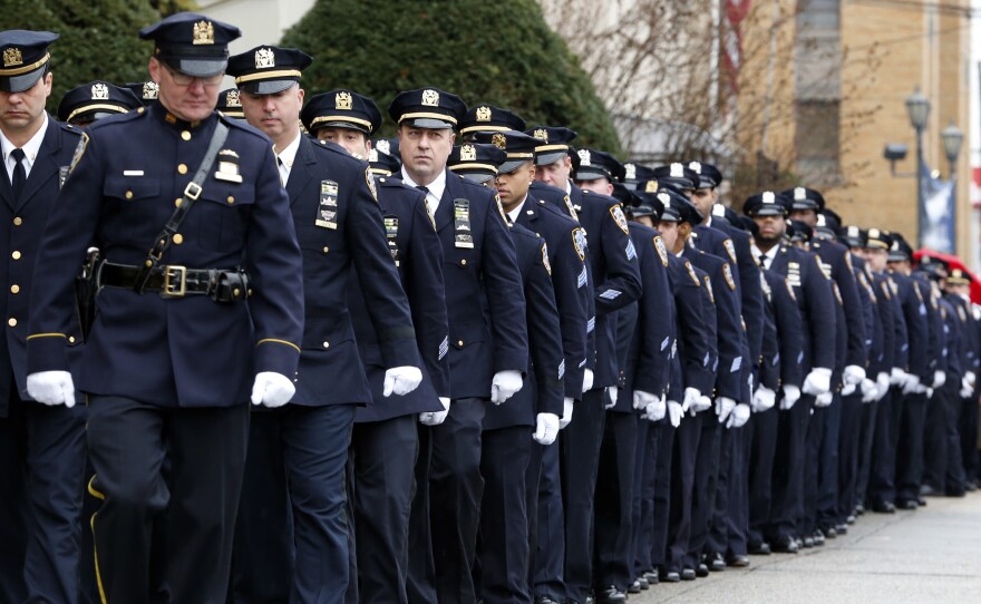 New York City police officers march before funeral services for police officer Wenjian Liu at Aievoli Funeral Home, in Brooklyn on Sunday. Liu and his partner were gunned down in an unprovoked attack on Dec. 20.