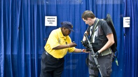 A Comic-Con attendee's fake weapons are inspected and tagged as safe before he can go on to the convention floor. 