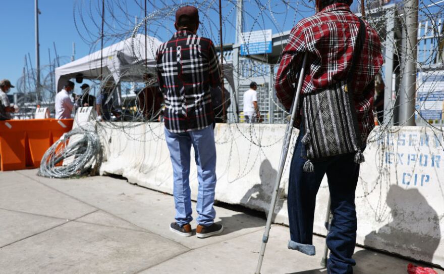 An asylum seeker waits outside the San Ysidro Port of Entry in Tijuana, Mexico. The Biden administration is bracing for a possible surge in migration if it lifts the pandemic border restrictions known as Title 42.