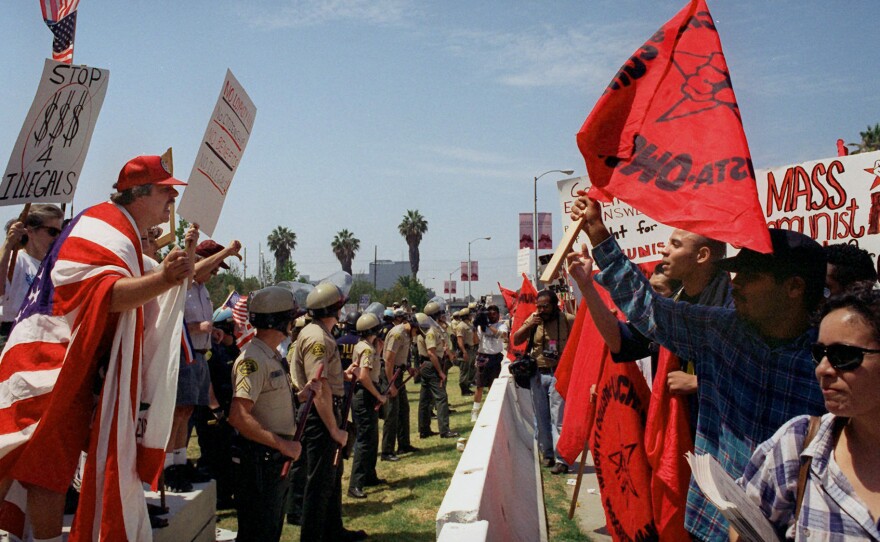 Activists for and against Proposition 187 rallied in Los Angeles in 1996, after it was thrown out by the courts. Political analysts say tough rhetoric and laws targeting undocumented immigrants could now have lasting political consequences for the national Republican party.