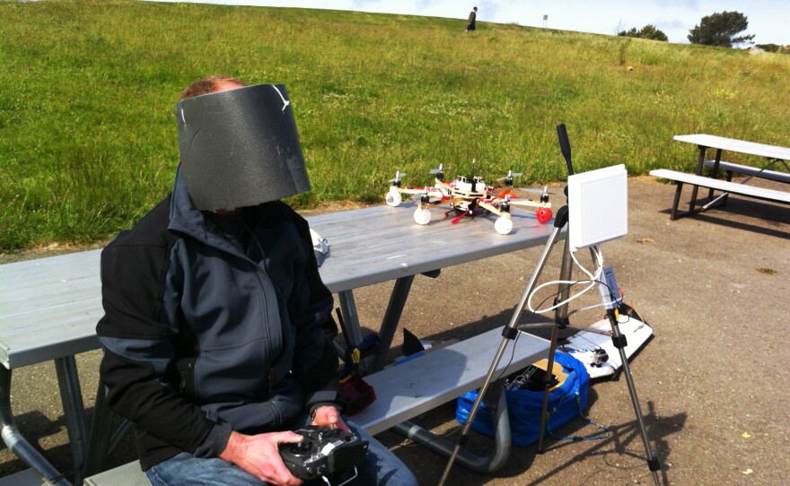 Drone enthusiast Andreas Oesterer wears homemade video goggles, wrapped in gray foam to block out the glare of the sun, as he flies a drone over Cesar Chavez Park.