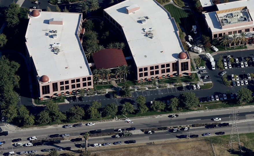 A police helicopter hovers around the Inland Regional Center in San Bernardino, Calif., the scene of a mass shooting on Wednesday.