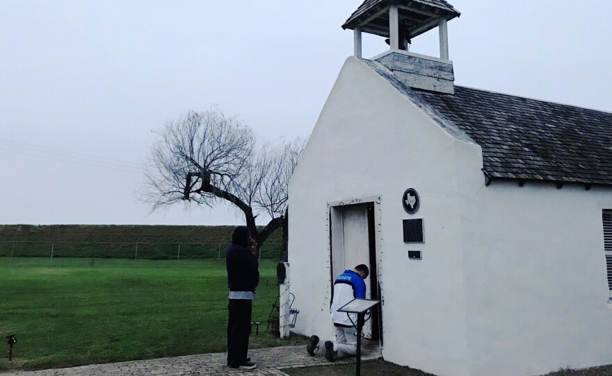 Two men pray at an early morning service at La Lomita chapel, a historical landmark in Mission, Texas.