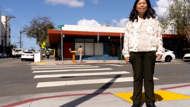 June Wong stands in front of what used to be "Lucky's Golden Phenix Restaurant" in North Park on Thursday, April 3, 2025. The street sign behind her will soon be changed to "Lucky Lane."