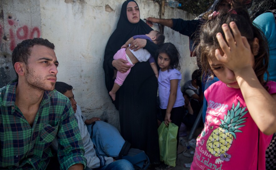 A weary family, who said their passports were lost at sea after their boat was attacked, bounced back and forth between two camps for migrants on Lesbos. Neither the camp reserved for Syrians nor the other for everyone else accepted them.