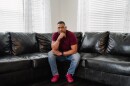Tyrone Ferrens, a plant electrician at Under Armour, sits for a portrait in his house in Aberdeen, Md.